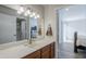 Bathroom features a wooden vanity, mirror with vanity lighting, and doorway to bedroom at 9275 E Mission Ln # 206, Scottsdale, AZ 85258