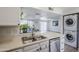 Contemporary kitchen featuring stainless steel appliances, a double sink, and convenient access to a laundry area at 9275 E Mission Ln # 206, Scottsdale, AZ 85258