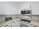 Well-lit kitchen showcasing white cabinetry, stainless steel microwave, and an electric stove at 9275 E Mission Ln # 206, Scottsdale, AZ 85258