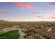 Expansive aerial shot of a neighborhood nestled in a desert landscape, with a golf course winding through the homes at 9280 E Thompson Peak Pkwy # 25, Scottsdale, AZ 85255