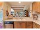 Bright kitchen with breakfast bar features wood cabinets, tile floors, and southwest details at 9280 E Thompson Peak Pkwy # 25, Scottsdale, AZ 85255