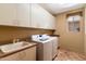 Functional laundry room with ample cabinet space, tile floor, and modern appliances at 9280 E Thompson Peak Pkwy # 25, Scottsdale, AZ 85255