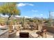 Relax by the outdoor fire pit with comfortable seating and desert views from the stone-paved patio at 9280 E Thompson Peak Pkwy # 25, Scottsdale, AZ 85255