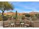 Scenic outdoor seating area on a stone patio, overlooking lush desert landscape and mountain views at 9280 E Thompson Peak Pkwy # 25, Scottsdale, AZ 85255