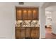 Stylish bar area with custom cabinetry, granite countertop, and mirrored backsplash at 9331 E La Posada Ct, Scottsdale, AZ 85255