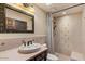 Bathroom features a framed mirror, neutral-toned tile, and a stylish vanity with updated fixtures at 9331 E La Posada Ct, Scottsdale, AZ 85255