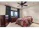 Comfortable bedroom with a ceiling fan, wooden furniture, and natural light coming through a window at 9331 E La Posada Ct, Scottsdale, AZ 85255