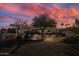 Stunning desert home with mature landscaping and a vibrant sunset sky backdrop at 9331 E La Posada Ct, Scottsdale, AZ 85255