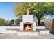 Outdoor fireplace with a brick hearth and plenty of space for seating around the area at 9331 E La Posada Ct, Scottsdale, AZ 85255