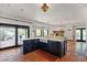 Modern kitchen with a center island, farmhouse sink, stainless appliances, and ample natural light through sliding glass doors at 9331 E La Posada Ct, Scottsdale, AZ 85255