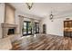 Spacious living room featuring a stone fireplace, wood floors, and stylish lighting at 9331 E La Posada Ct, Scottsdale, AZ 85255