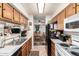 Efficient kitchen layout with wood cabinets, essential appliances, and a view into the adjacent dining area at 9345 N 92Nd St # 201, Scottsdale, AZ 85258