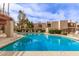 Community swimming pool with lounge chairs and manicured bushes surrounded by condo buildings at 9345 N 92Nd St # 201, Scottsdale, AZ 85258