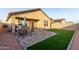 Outdoor patio with dining set and well-maintained artificial grass at 9539 W Agora Ln, Tolleson, AZ 85353