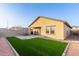 View of the backyard with artificial grass, patio and covered porch at 9539 W Agora Ln, Tolleson, AZ 85353