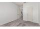 Unfurnished bedroom with neutral carpet, white walls, and an open doorway at 9539 W Agora Ln, Tolleson, AZ 85353