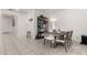 Bright dining area featuring a wooden table set, modern shelving, and tiled floors at 9539 W Agora Ln, Tolleson, AZ 85353