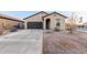 Charming home featuring a two-car garage, desert landscaping, and a welcoming arched entryway at 9539 W Agora Ln, Tolleson, AZ 85353