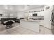 Open-concept kitchen flowing into the living room, featuring a large island and modern appliances at 9539 W Agora Ln, Tolleson, AZ 85353