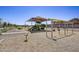 Community playground with swings, slides, and shaded seating area at 9539 W Agora Ln, Tolleson, AZ 85353