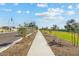 Scenic street view with landscaped sidewalks and green spaces at 9539 W Agora Ln, Tolleson, AZ 85353