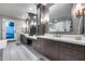 Modern bathroom with dual sinks, white countertops, and dark wood cabinetry at 9921 E Doubletree Ranch Rd, Scottsdale, AZ 85258