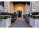 Inviting entryway featuring a decorative door, sconce lighting, and lush landscaping at 9921 E Doubletree Ranch Rd, Scottsdale, AZ 85258