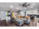 Open-concept living room featuring hardwood floors, gray sofa with orange pillows, and views of the kitchen and dining areas at 9921 E Doubletree Ranch Rd, Scottsdale, AZ 85258