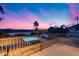 Relaxing backyard with a pool and an iron fence, set against a vibrant sunset sky at 9921 E Doubletree Ranch Rd, Scottsdale, AZ 85258