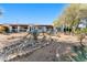 Expansive backyard showcases desert landscaping, a rock-lined water feature, and the home's covered patio at 100 N Lazy Fox Rd # 3, Wickenburg, AZ 85390