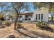 Rear exterior featuring arched windows, stucco walls, and an inviting patio area with desert landscape at 100 N Lazy Fox Rd # 3, Wickenburg, AZ 85390