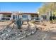 Beautiful desert backyard with natural rock accents, mature vegetation, and a covered patio at 100 N Lazy Fox Rd # 3, Wickenburg, AZ 85390