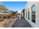 Backyard of a house with tiled patio, desert landscape, and white stucco exterior at 100 N Lazy Fox Rd # 3, Wickenburg, AZ 85390