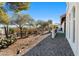 Backyard landscape featuring desert vegetation, tiled patio, and neutral colors at 100 N Lazy Fox Rd # 3, Wickenburg, AZ 85390