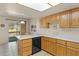Open kitchen with wood cabinets, countertop seating, and a stainless steel dishwasher at 100 N Lazy Fox Rd # 3, Wickenburg, AZ 85390