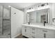 Modern bathroom with dual vanity, marble countertops, framed mirror, and luxurious tiled shower at 10252 N 46Th Dr, Glendale, AZ 85302