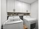 Functional laundry room featuring white cabinets, shelving, and modern LG washer and dryer units at 10252 N 46Th Dr, Glendale, AZ 85302
