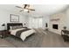 Spacious main bedroom features a striking fireplace, ceiling fan, and stylish contemporary furnishings at 10252 N 46Th Dr, Glendale, AZ 85302