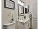 A well-lit bathroom featuring a white vanity, decorative mirror, and modern fixtures at 10353 W Atlantis Way, Tolleson, AZ 85353