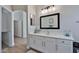 Bright bathroom features a white vanity, framed mirror, and wood-look flooring at 10353 W Atlantis Way, Tolleson, AZ 85353