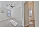 Sunlit bedroom with plush carpet, ceiling fan, and adjacent bathroom with a soaking tub at 10353 W Atlantis Way, Tolleson, AZ 85353
