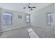 Bright, carpeted bedroom featuring three windows and a ceiling fan at 10353 W Atlantis Way, Tolleson, AZ 85353