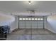 Well-lit garage features a white door, concrete flooring, and overhead storage at 10353 W Atlantis Way, Tolleson, AZ 85353
