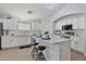 Well-lit kitchen featuring an island with seating, white cabinets, and stainless steel appliances at 10353 W Atlantis Way, Tolleson, AZ 85353