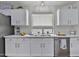 Bright kitchen with stainless steel appliances, a double sink, and white cabinets at 10353 W Atlantis Way, Tolleson, AZ 85353