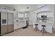 Well-lit kitchen with white cabinets, stainless steel appliances, and a breakfast bar at 10353 W Atlantis Way, Tolleson, AZ 85353