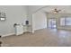 Open-concept living room boasts vaulted ceilings, a ceiling fan, and sliding glass doors to the backyard at 10353 W Atlantis Way, Tolleson, AZ 85353