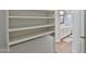 Walk-in closet featuring white shelving and rods with hallway and bathroom view at 10353 W Atlantis Way, Tolleson, AZ 85353