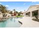 Great backyard area featuring a pool, built-in grill, covered patio, and lush landscaping at 11232 E Palomino Rd, Scottsdale, AZ 85259