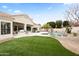 Expansive backyard featuring a swimming pool, built-in grill, covered patio, and lush landscaping at 11232 E Palomino Rd, Scottsdale, AZ 85259